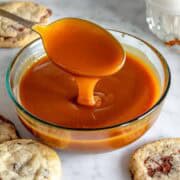 Caramello salato in una ciotola di vetro con un cucchiaio.