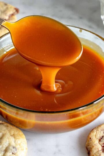 Caramello salato in una ciotola di vetro con un cucchiaio.