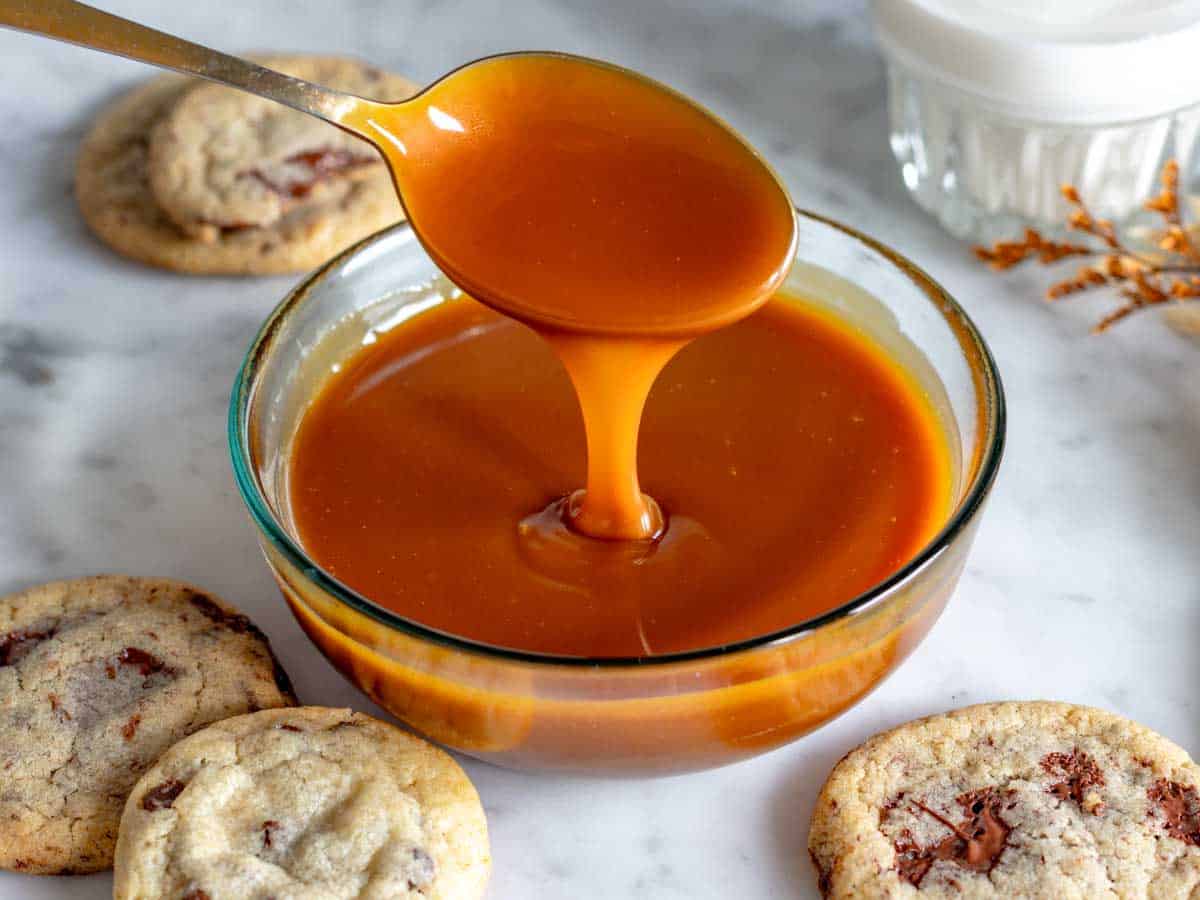 Caramello salato in una ciotola di vetro e su un cucchiaio.