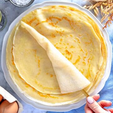 Una mano femminile che tenga una crepes.