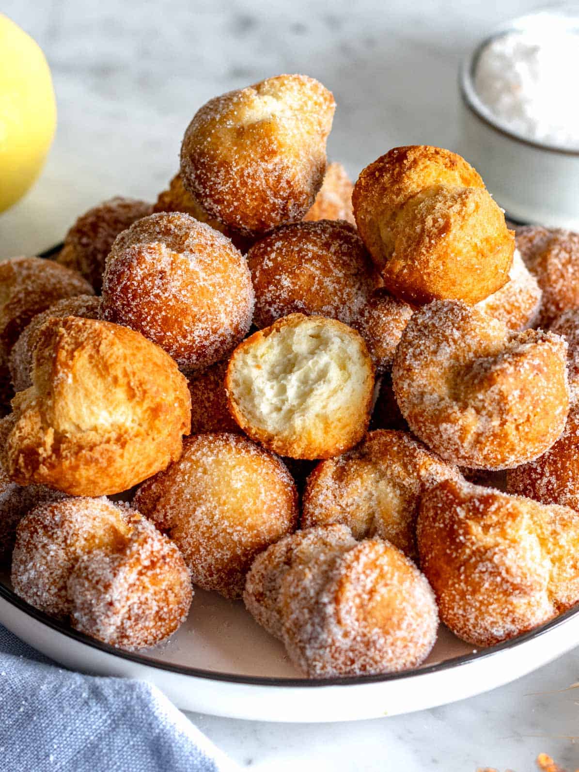 Castagnole fritte con zucchero in una ciotola.