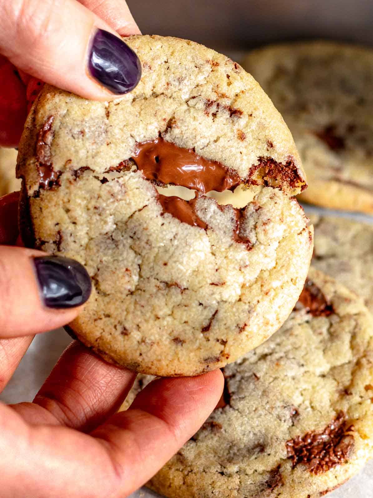 Louise che rompe un cookie a metà e mostra il cioccolato.