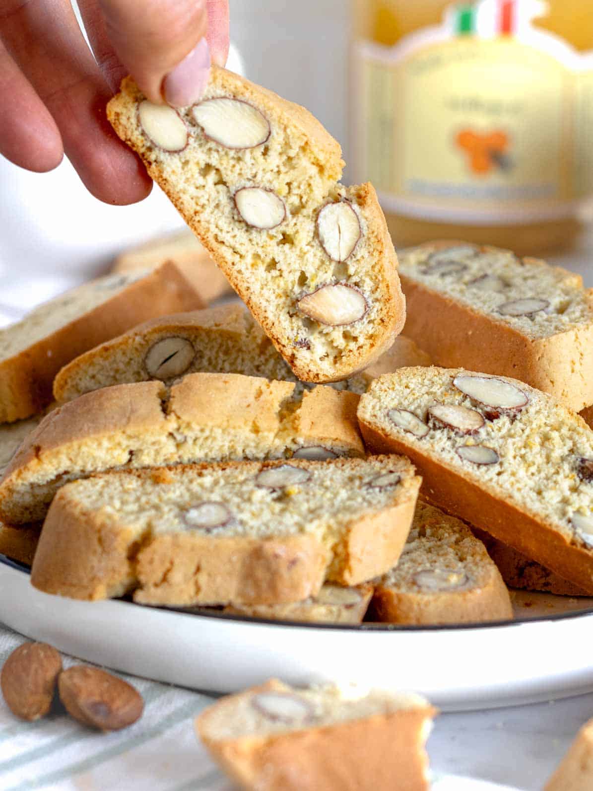 Mano femminile che prende un cantucci con mandorle.