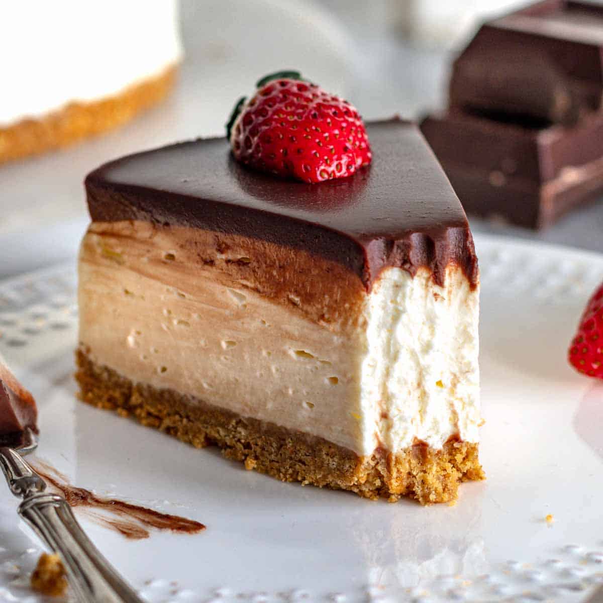 Una fetta di cheesecake fredda con ganache al cioccolato e fragole.