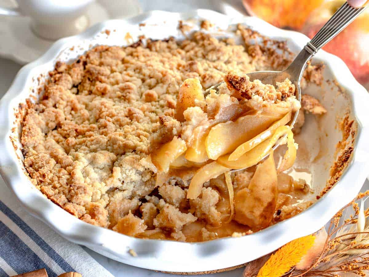 Crumble di mele servita con un cucchiaio d'argento. 