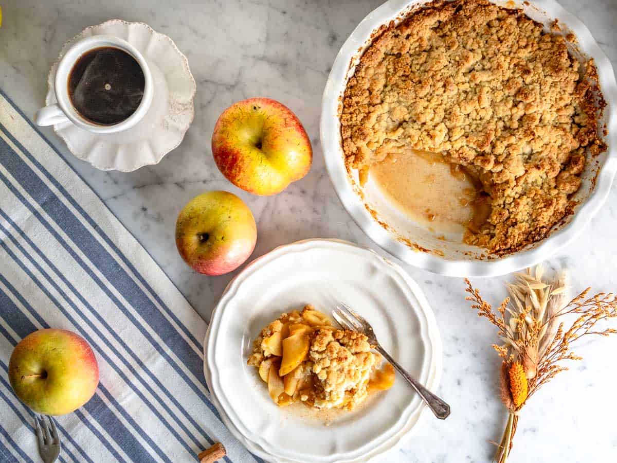 Una porzione di crumble di mele su un piatto bianco.